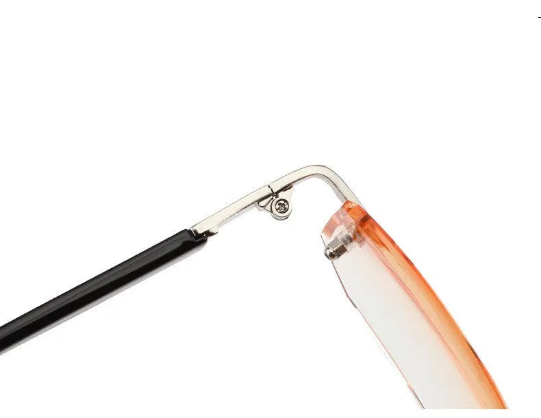 Diamond-cut metal reading glasses with tan frame and black lenses on a plain background