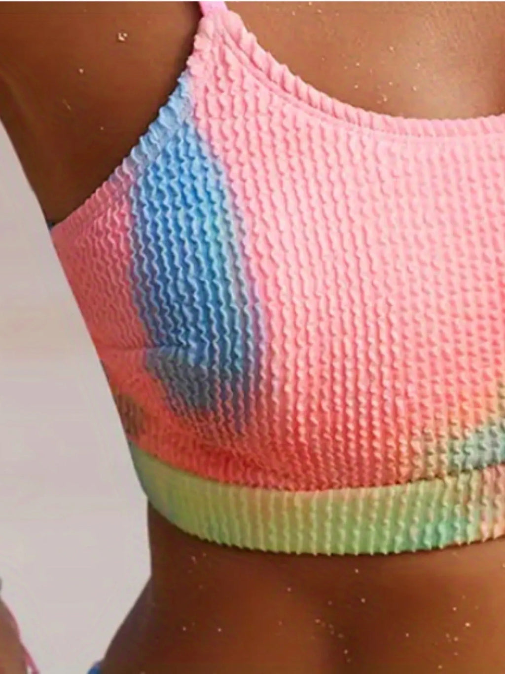 Women's tie-dye pleated split bikini in polyester fabric showing gradient pattern and textured detailing