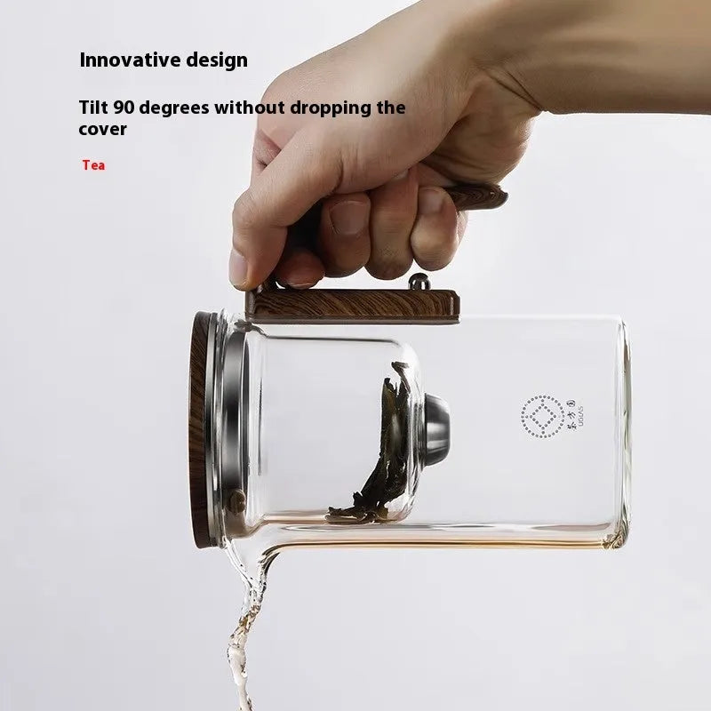 Glass teapot with wooden handle showing magnetic tea separation button and detachable inner infuser.