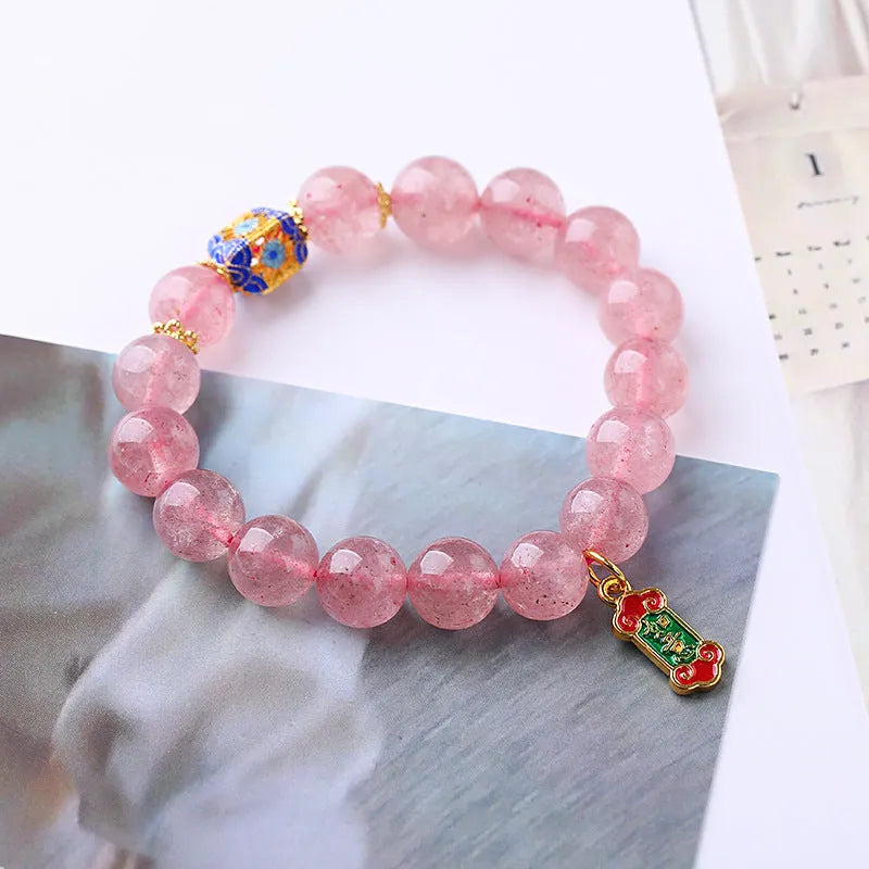 Pink strawberry quartz crystal bracelet with hand-woven construction and traditional Chinese ruyi lucky symbols