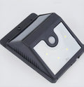 Set of four black solar-powered outdoor LED lights with motion sensors.