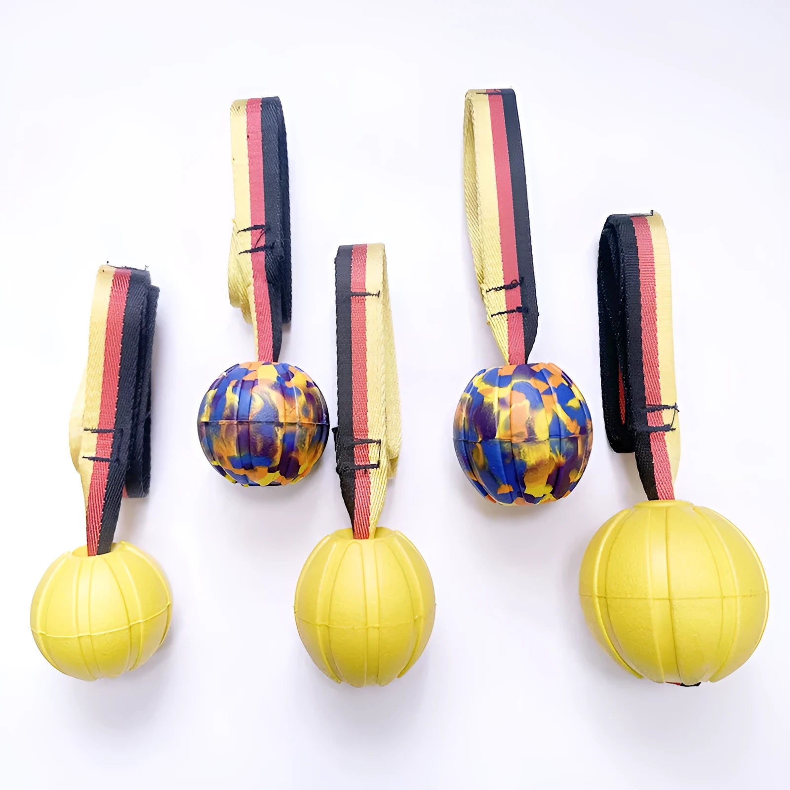Yellow and camouflage coloured EVA floating dog training balls in different sizes on a blue background.