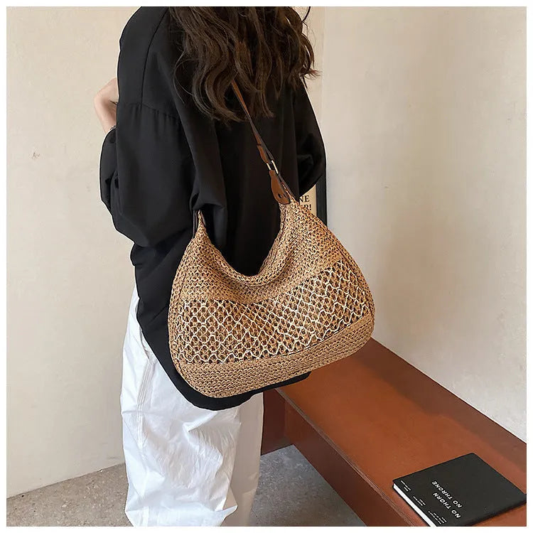 Khaki coloured straw cross body bag with a square shape and an external sandwich pocket.