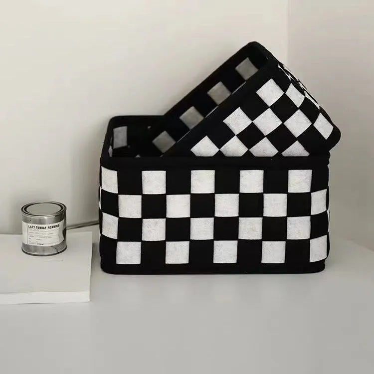 Black and white checkerboard patterned felt folding storage basket shown in its assembled box shape.