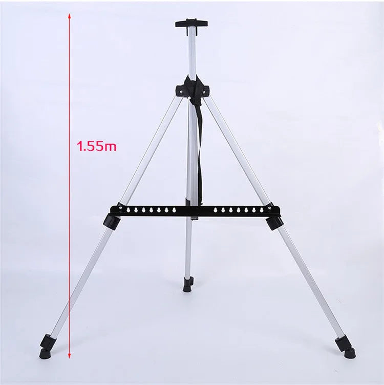 Silver aluminium alloy adjustable easel with metal tray, collapsed for table top use, next to a black nylon carrying bag