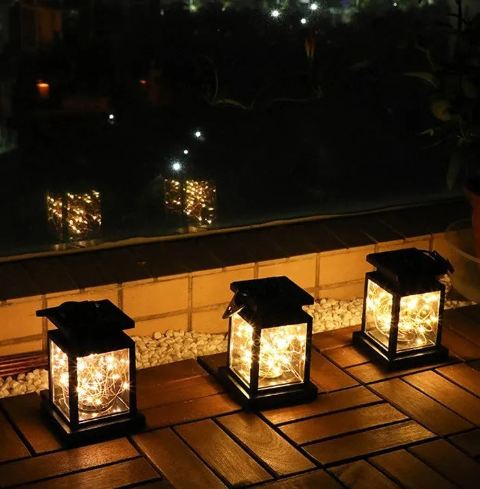 Black solar wind lamp with warm white LED light on outdoor table