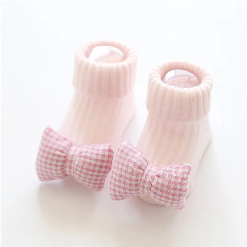 Cotton baby socks with non-slip soles in multiple designs including bows, stars, and animal prints.