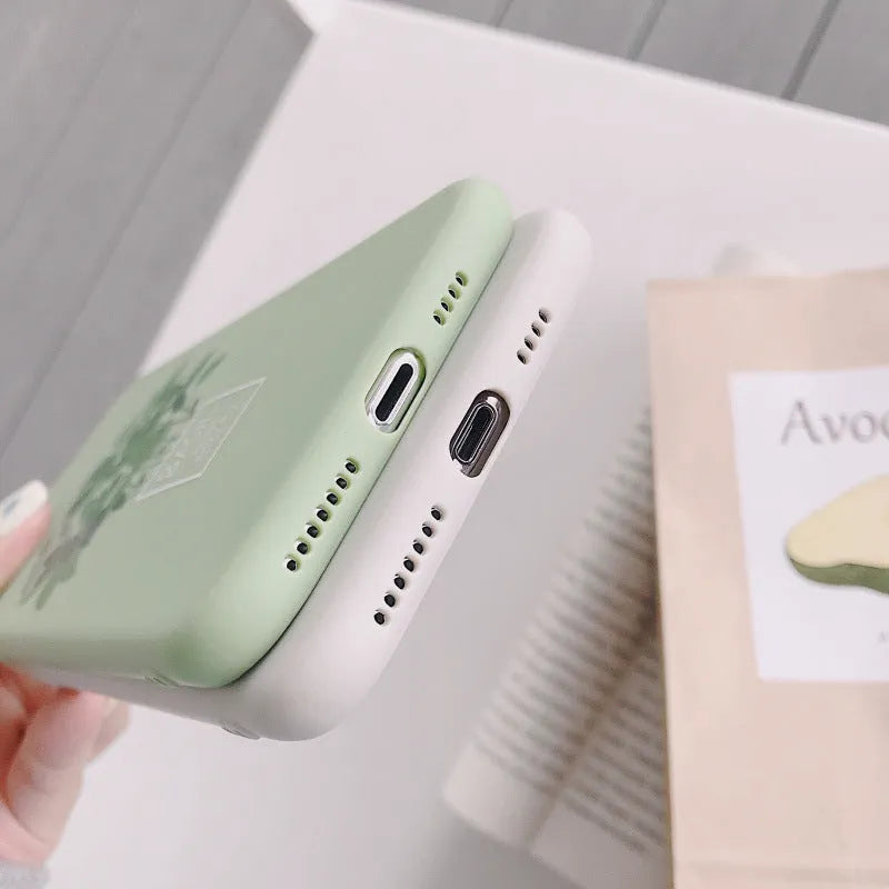 White silicone iPhone case with a painted green plant pattern on the back.