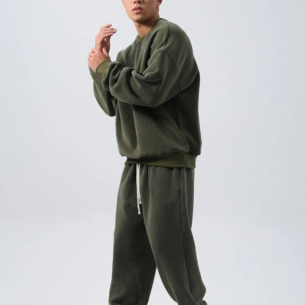 Men's black loose fit polar fleece winter sports suit with long sleeve coat and trousers on a hanger.