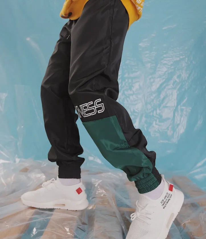 Green Japanese hip hop sweatpants with hit colour stitching, letter print, and bouquet floral design on a low-waist drawstring style