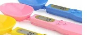 White digital spoon scale with LCD display showing weight measurement for kitchen ingredients
