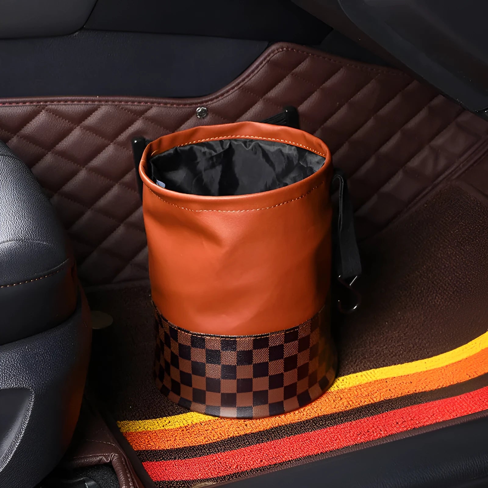 Leather retractable car trash can shown in folding design with carry handle