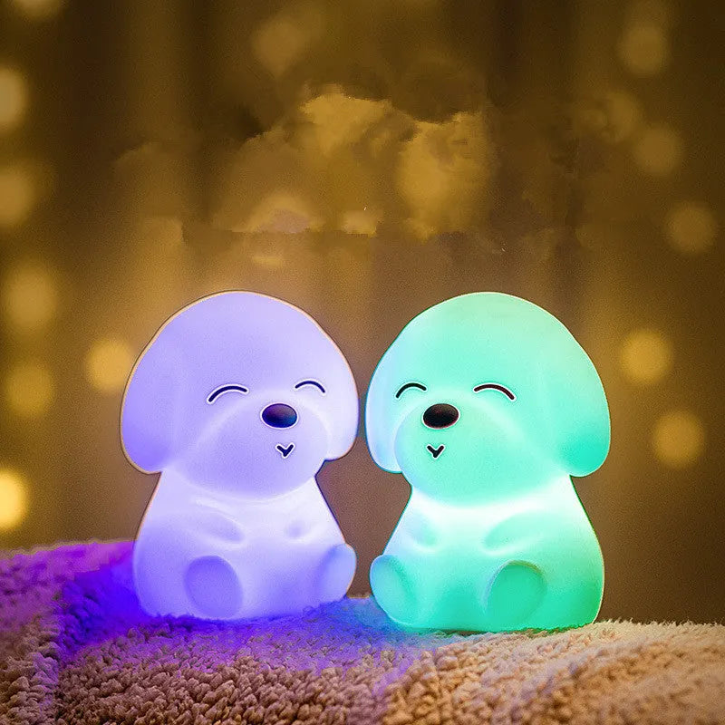 White silicone puppy-shaped LED night light with soft glow on a flat surface