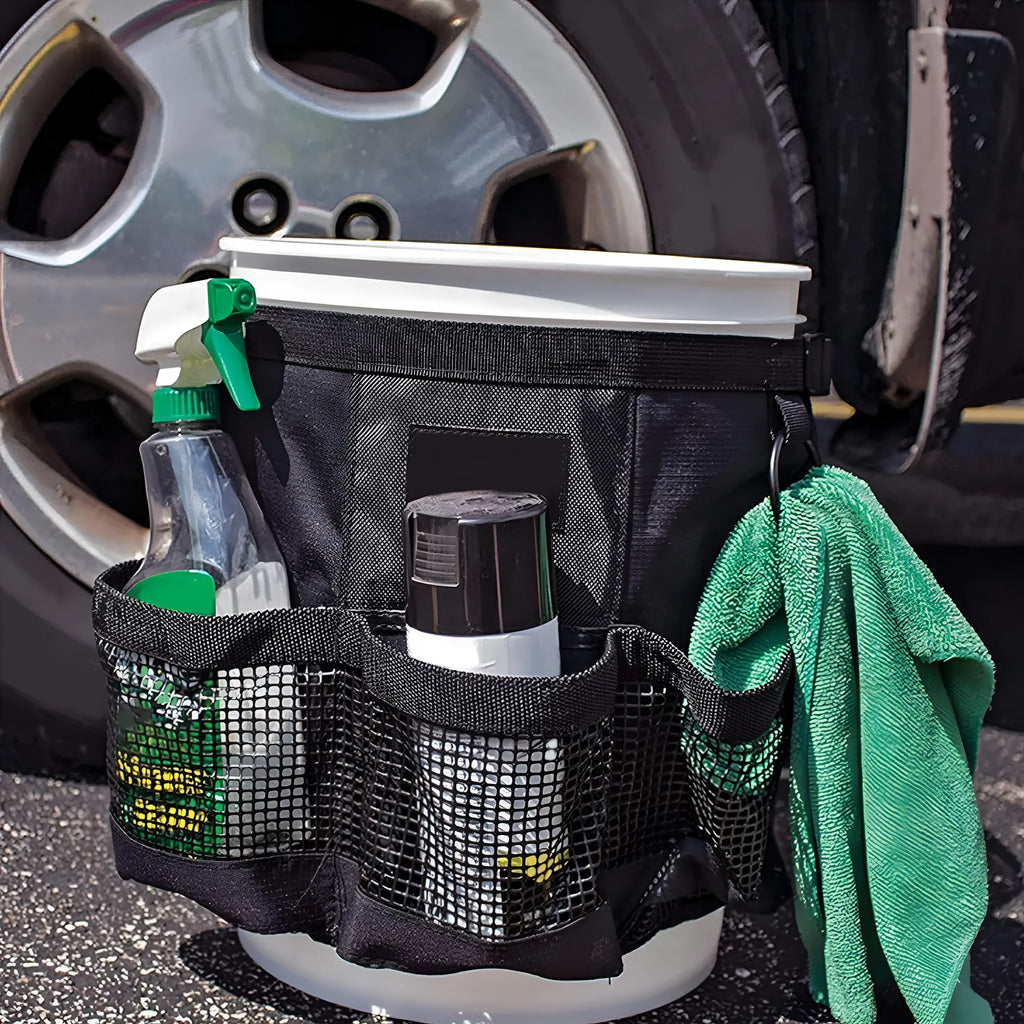 Black cylindrical polyester storage bag with straps hanging from a 5 gallon bucket.