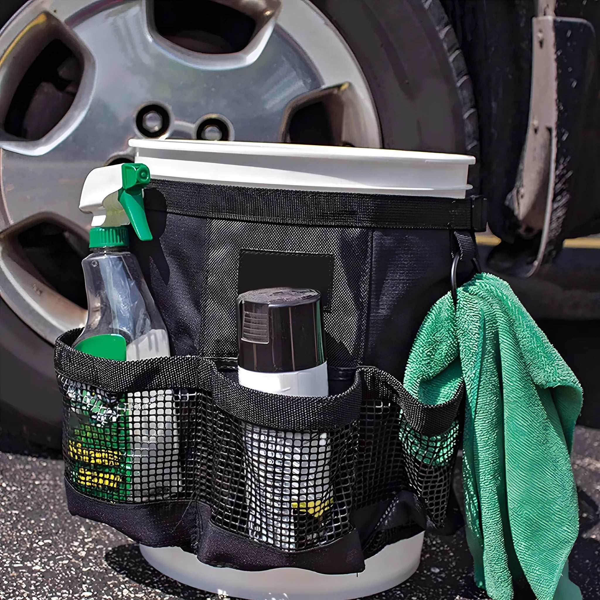 Black cylindrical polyester storage bag with straps hanging from a 5 gallon bucket.
