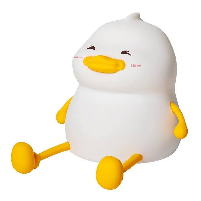 Chubby silicone pat night light on a desk showing soft LED glow and USB charging cable.