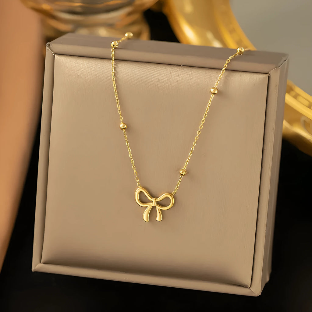 Gold electroplated bow necklace with adjustable 41-50cm length and cross chain