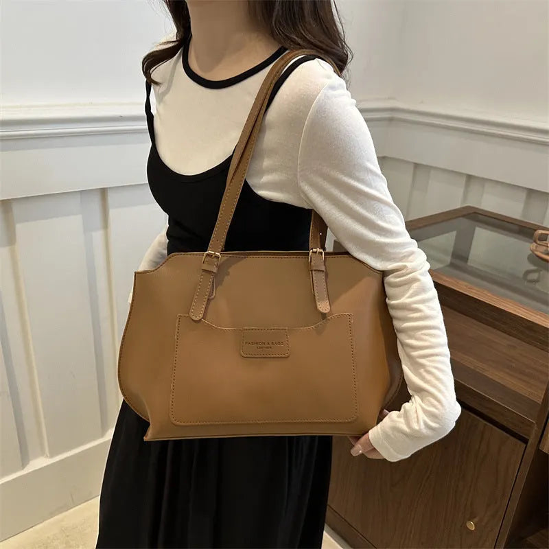 Horizontal square PU tote bag for women in black, showing external sandwich pocket and double shoulder straps.
