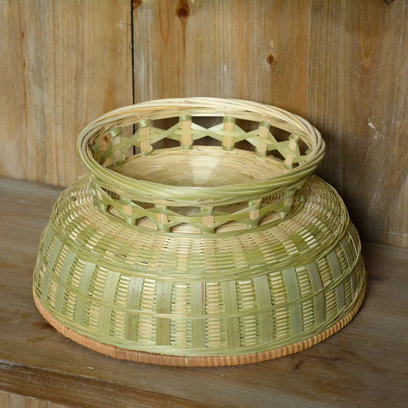 Handmade natural bamboo woven storage basket on a wooden surface.