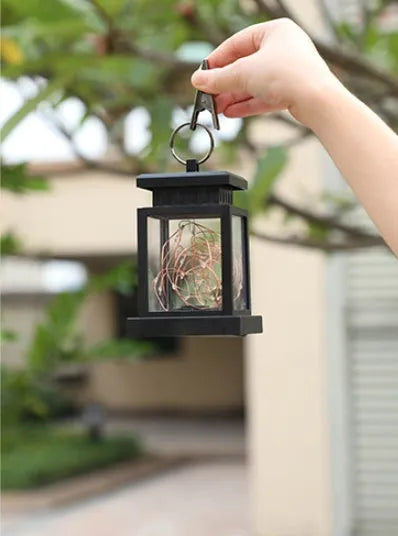 Black solar wind lamp with warm white LED light on outdoor table