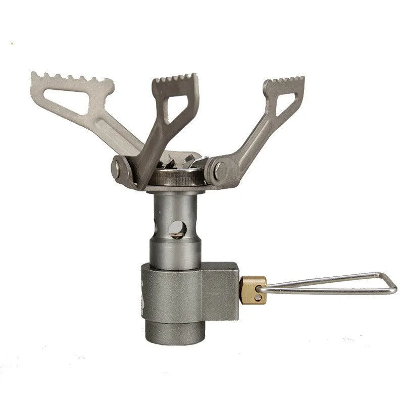 Portable metal propane camping stove with one-piece furnace design on a outdoor surface.
