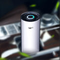 White ABS car air purifier with negative ion and USB power, placed in a cup holder