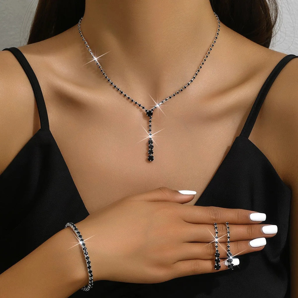 Three-piece bridal jewellery set showing necklace, bracelet and earrings with rhinestone pendant and heart-shaped design