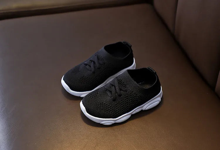 Children's white lazy slip-on shoe with fabric upper and textured non-slip rubber sole.