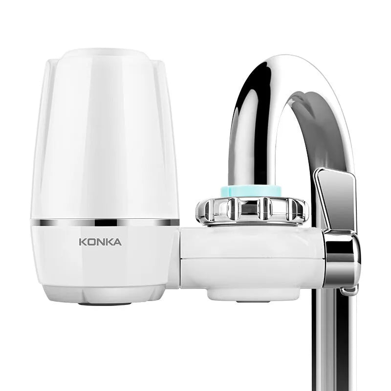 White plastic faucet water purifier with ceramic filter cartridge mounted on kitchen tap