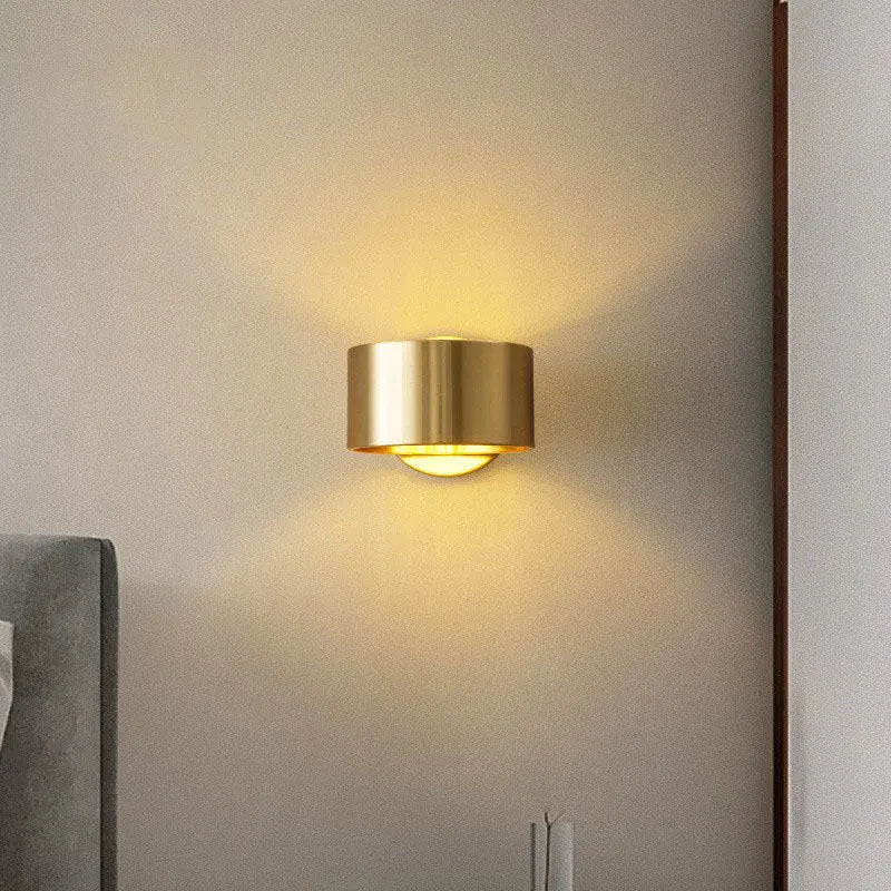 Modern minimalist copper wall lamp in black finish, mounted on a plain wall.