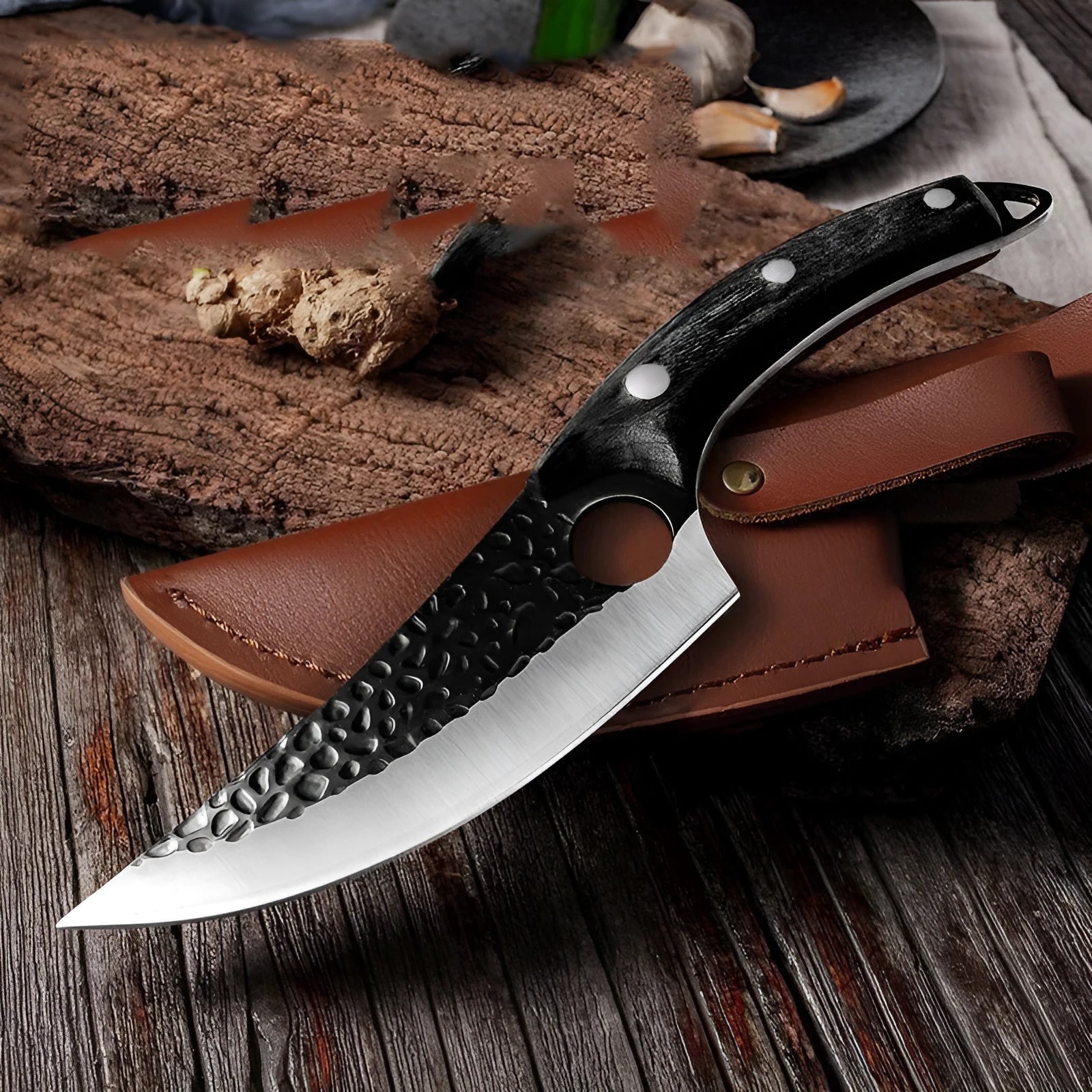 Forged boning knife set with curved scimitar blade and leather sheath on a dark surface.