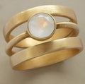 Gold-coloured geometric titanium steel ring with a micro-inlaid white chalcedony pattern.