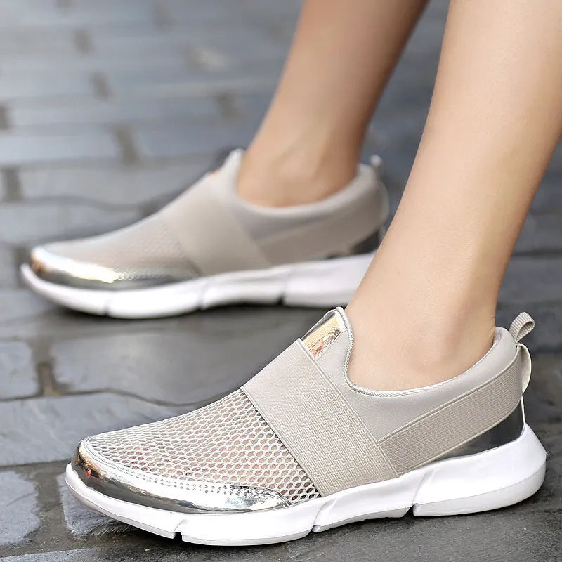 Low-cut blue, black, and grey women's sneakers with a mesh interior on a plain background.