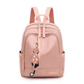 Black nylon casual backpack with external pockets, shown with adjustable straps and a soft handle.