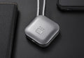 Compact pink USB portable air purifier necklace on a table with charging cable.