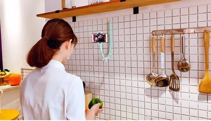 Black flexible rubber phone holder with suction cup base bent into an arc shape
