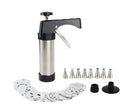 Stainless steel biscuit press gun with assortment of cookie moulds and piping nozzles on a baking sheet.