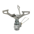 Portable metal propane camping stove with one-piece furnace design on a outdoor surface.