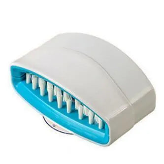 Blue kitchen cleaning brush with slots for utensils and a suction cup on a white wall.