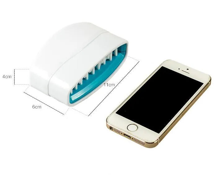 Blue kitchen cleaning brush with slots for utensils and a suction cup on a white wall.