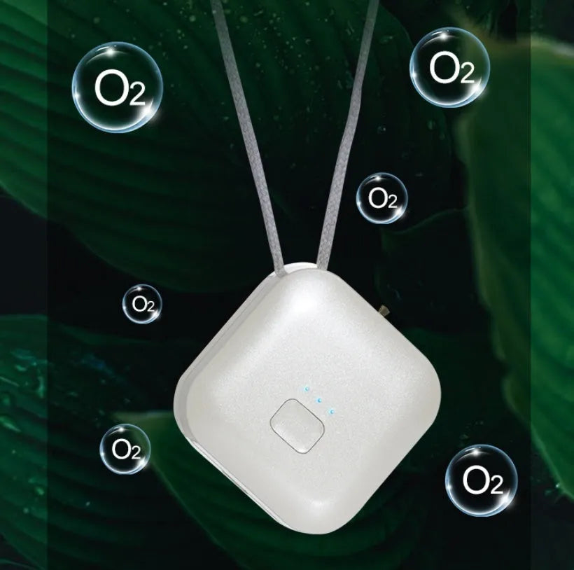 Compact pink USB portable air purifier necklace on a table with charging cable.