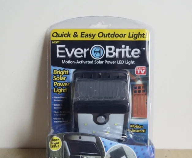 Set of four black solar-powered outdoor LED lights with motion sensors.