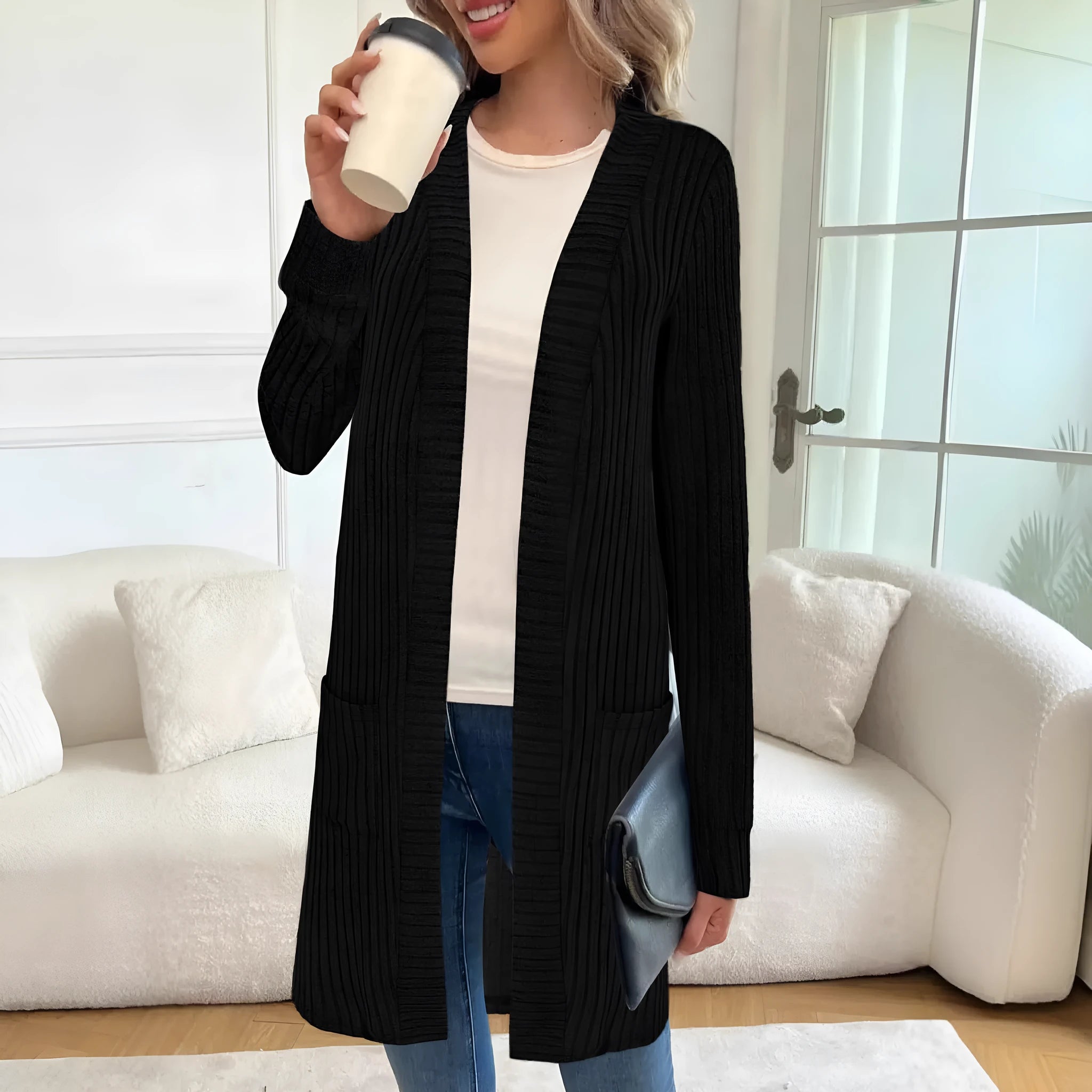 Long sleeve loose knitted cardigan jacket in black, shown with side pockets.
