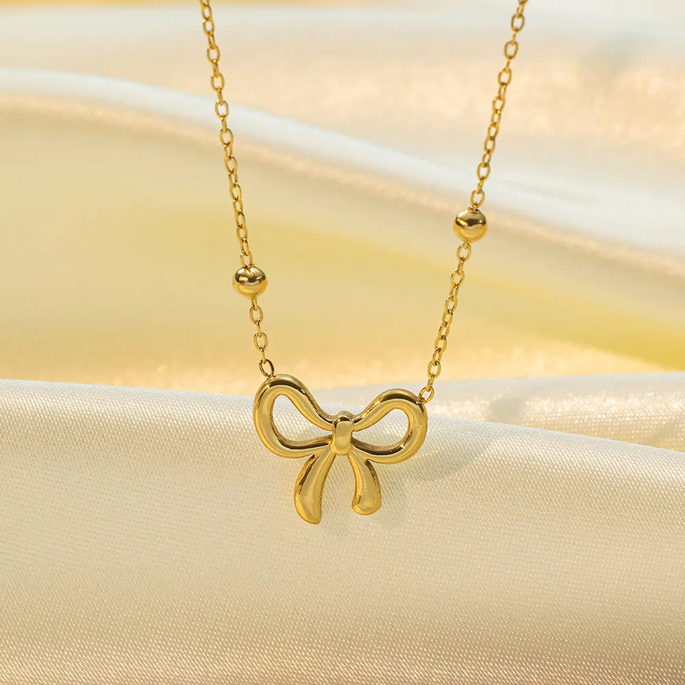 Gold electroplated bow necklace with adjustable 41-50cm length and cross chain