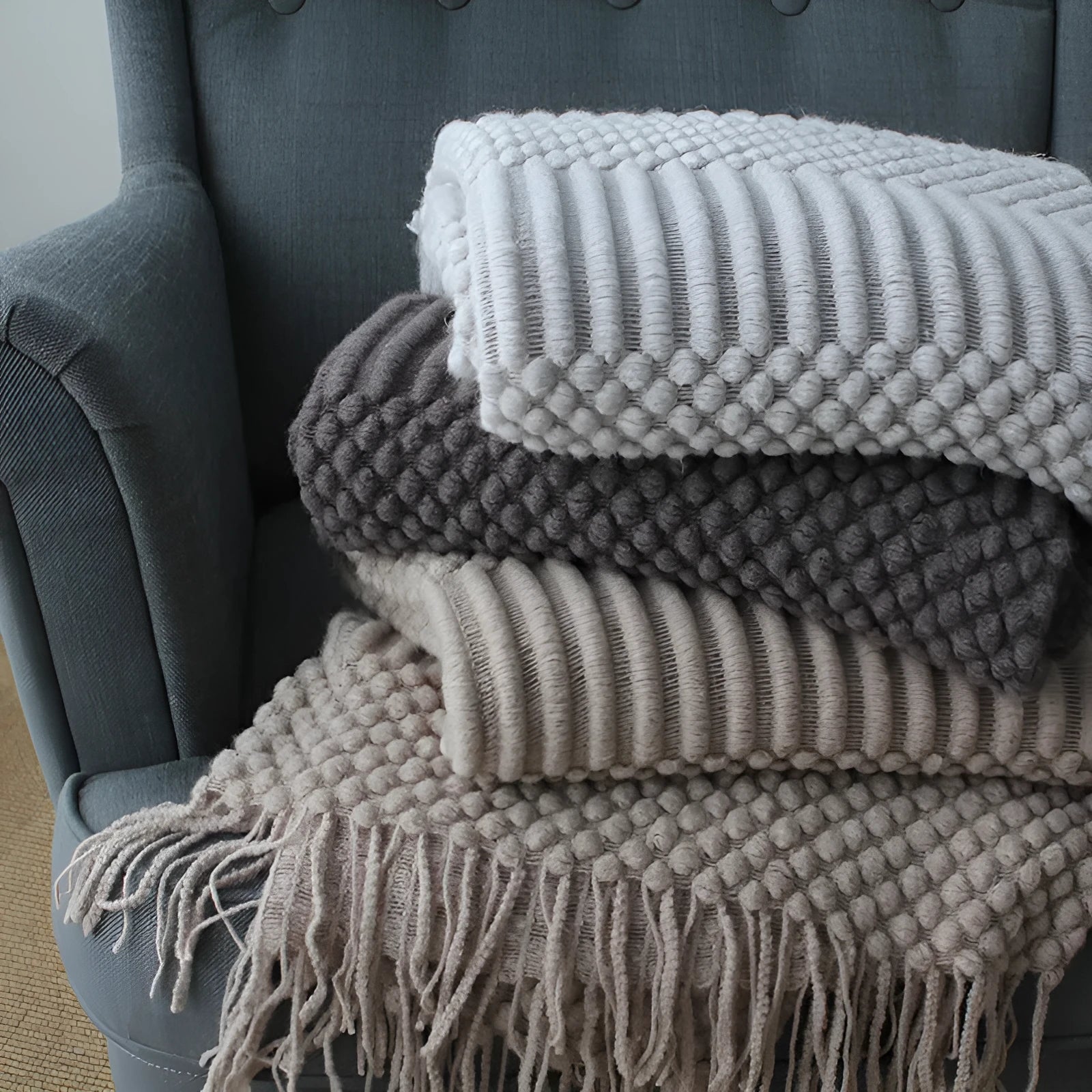 Small lightweight polyester nap blanket in dark grey, khaki, or light grey, shown folded, dimensions 127cm by 170cm.