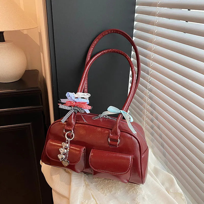 Retro pillow-shaped women's handbag in PU leather with a one shoulder strap, shown in a choice of colours.