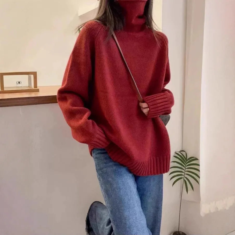A woman wearing a thick, loose grey turtleneck sweater with a textured curling pile collar.