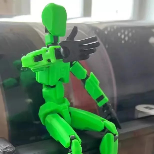 Multi-jointed 3D printed robot action model with movable limbs on a desk.