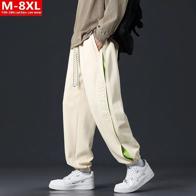 Men's grey green loose-fit cargo trousers with visible stitching detail and a banded ankle opening.
