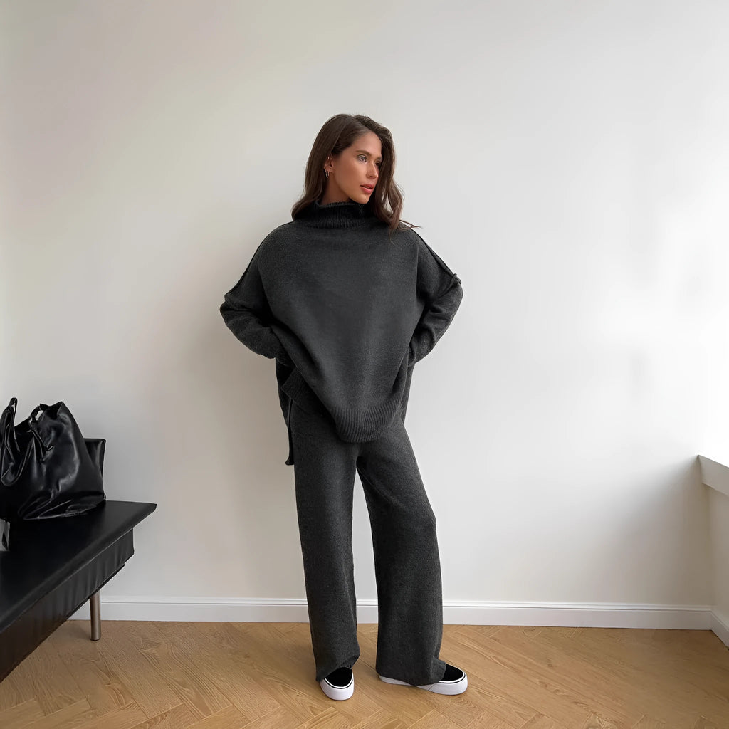 Women's dark grey knit co-ord suit with side-slit sweater top and matching trousers.